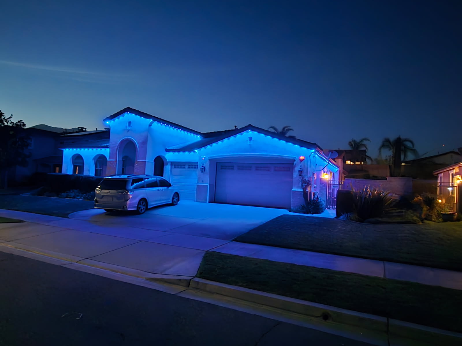 Blue permanent outdoor lights on a single-story home