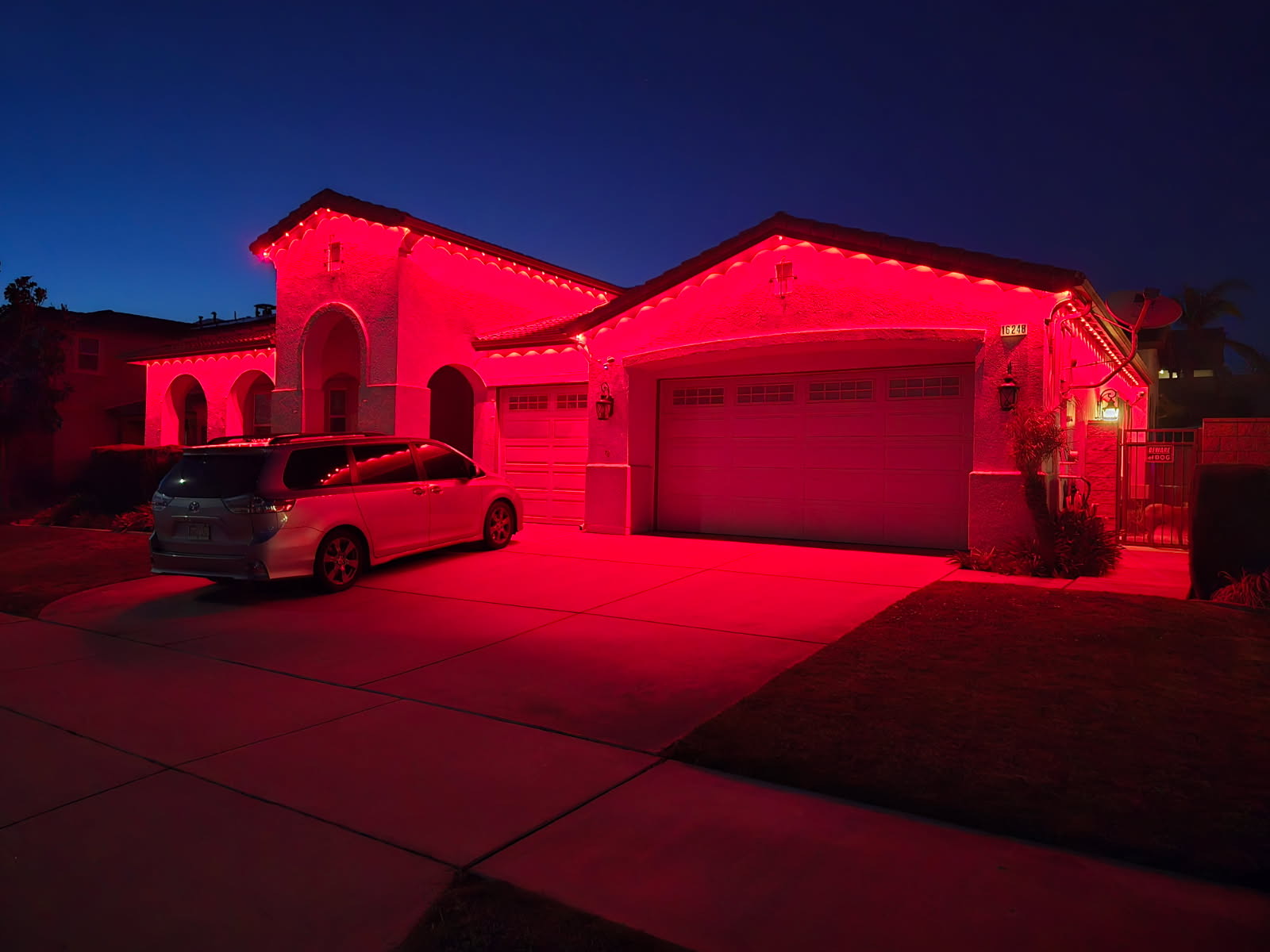 Red permanent outdoor lights on a single-story home